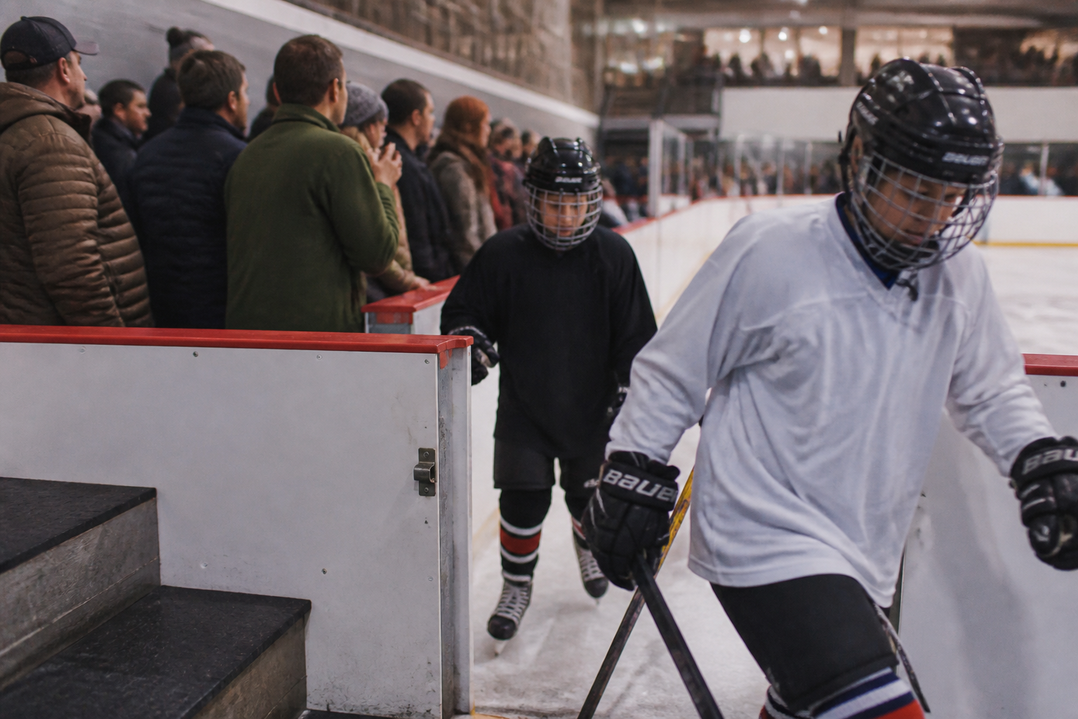 Youth hockey players enter the ice at Glacier Ice Rink while families watch a public skate session.